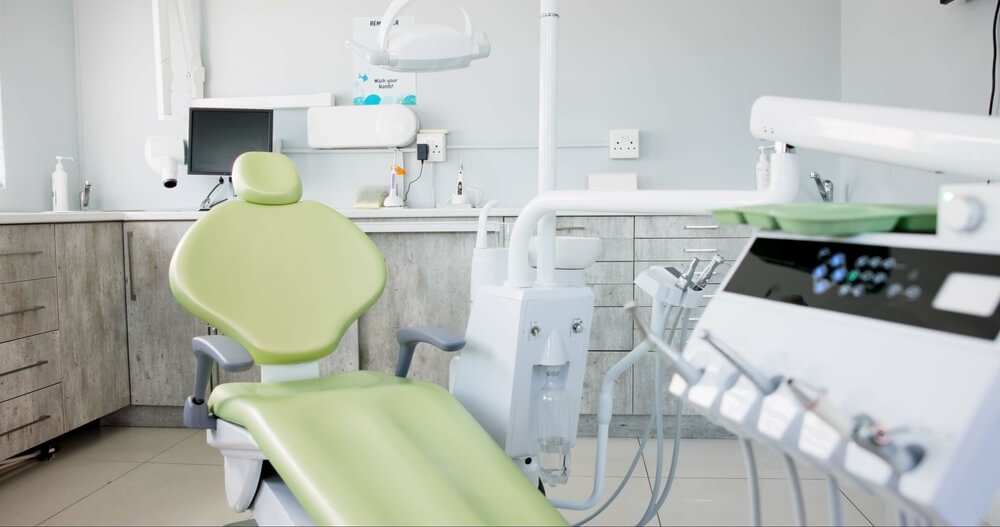 An empty dental room with chair and equipment