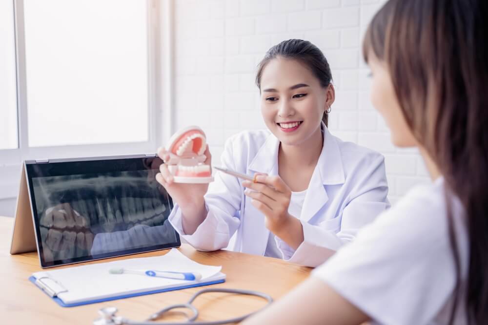an asian Zen Dental Marketing client dentist talks to her patient