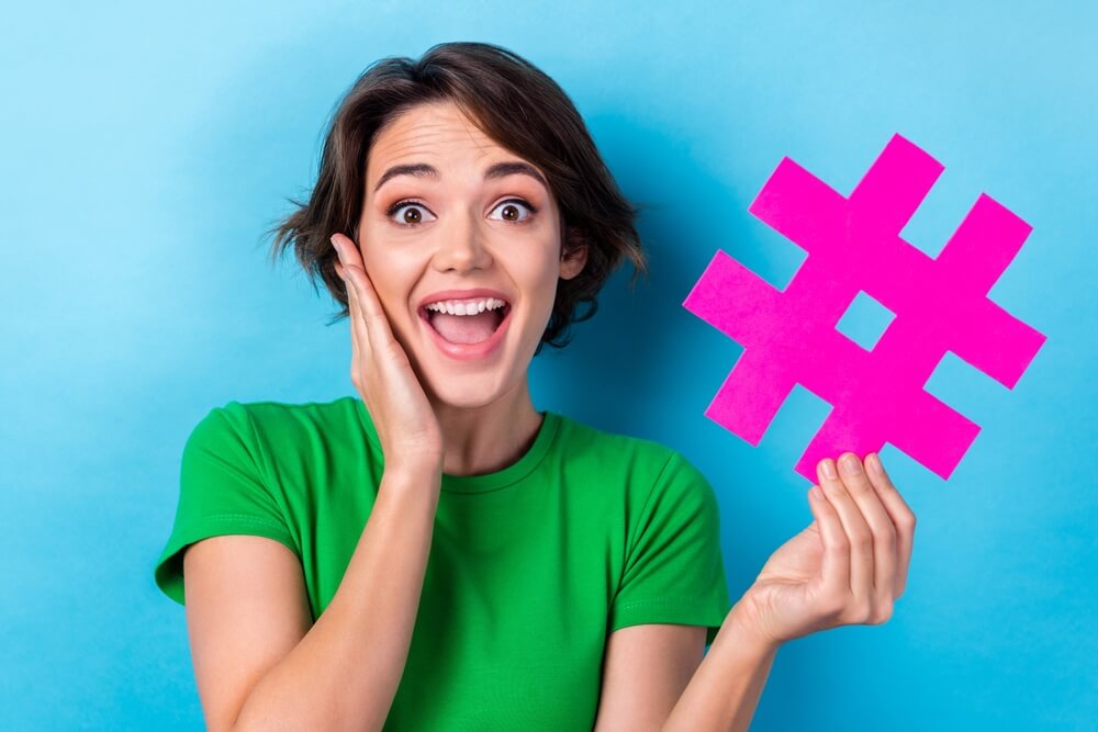 excited Zen Dental Marketing specialist holding hashtag cutout